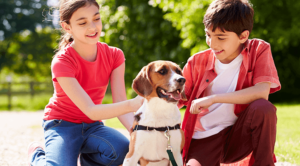 two young kids playing with their dog